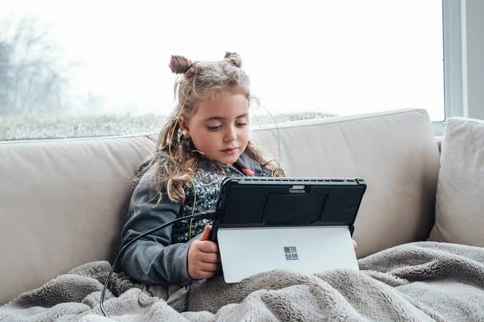 A young girl using a tablet during a neurofeedback session